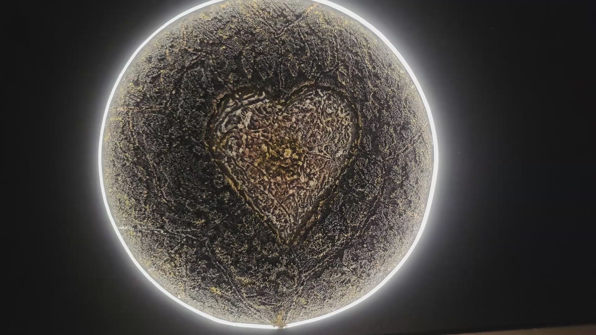 Cinematic presentation of Genesis, an illuminated handcrafted relief artwork from Project X. The glowing planetary form reveals a golden heart at its core, expressing the beginning of everything and the flow of love through the universe.